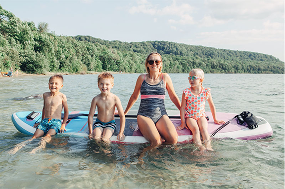 Family on an inflatable paddle board that was constructed by drop stitch welding